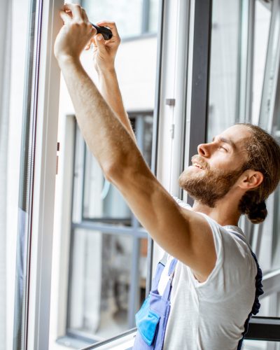 Workman adjusting window frames at home